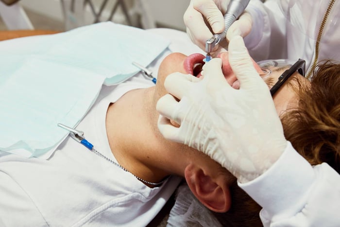 A person working on a patient's teeth