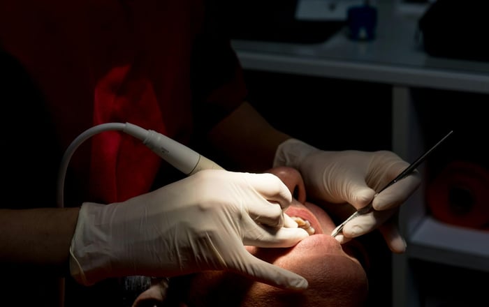 A person working on a patient's teeth