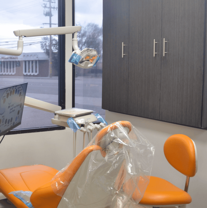 A dental chair in front of a window