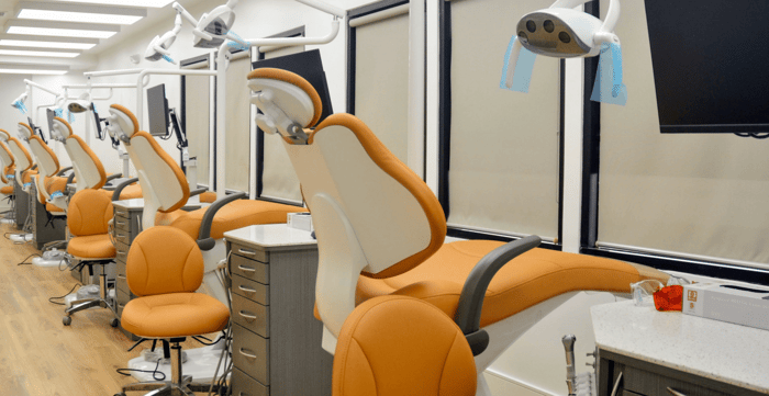 A row of dental chairs in front of a window