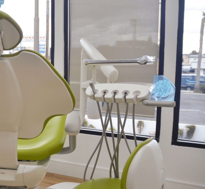A dental chair in front of a monitor