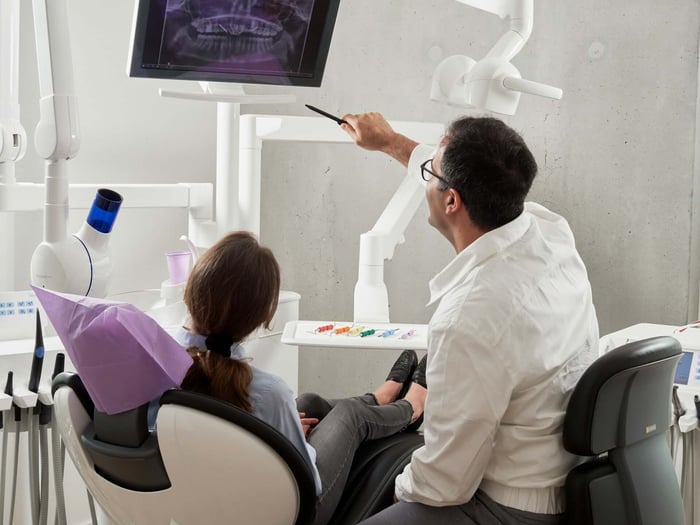 Dentist reviewing dental X-rays with a patient during a consultation about Medi-Cal Cover for Dental Adults