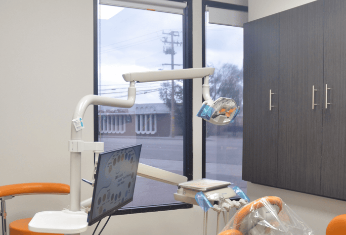 A dental chair in front of a monitor