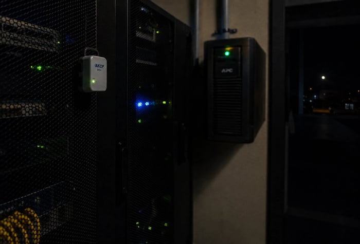 Cellular sensor mounted at server rack inlet for UPS temperature monitoring in a small server room during a power outage.