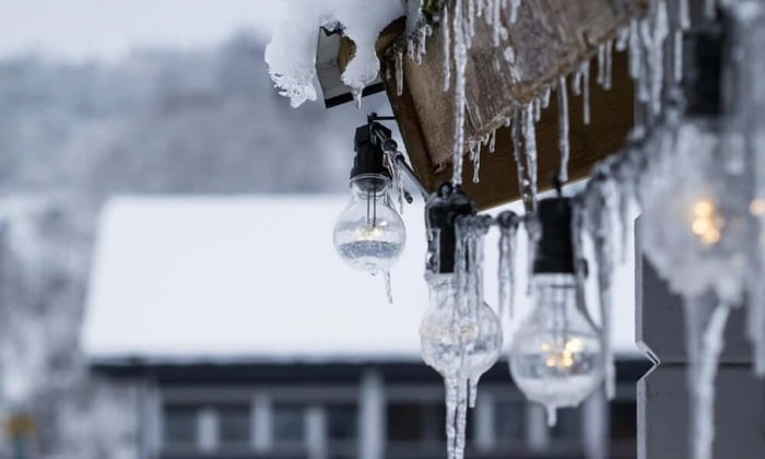 Icicles forming on outdoor light bulbs during a winter freeze, illustrating why a temperature alert system is essential for protecting vacant properties from cold weather damage