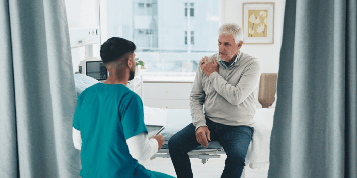 Clinician completing a validated pain assessment tool selection with an older adult patient in an outpatient clinic.
