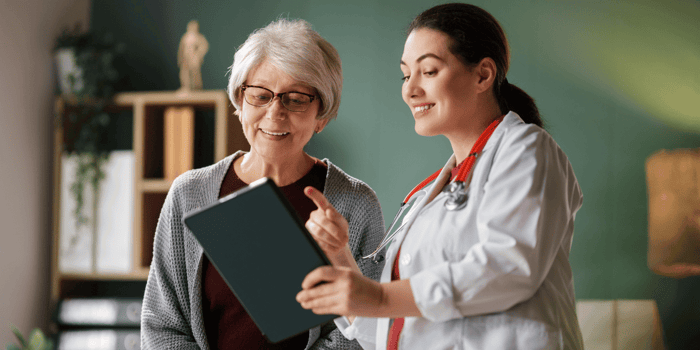 Clinician reviewing total shoulder arthroplasty rehabilitation protocol with patient in outpatient clinic, shoulder replacement recovery