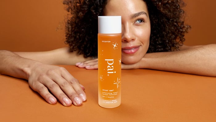 Model with face partially hidden behind the Pai Skincare Bright Now exfoliating toner for sensitive skin