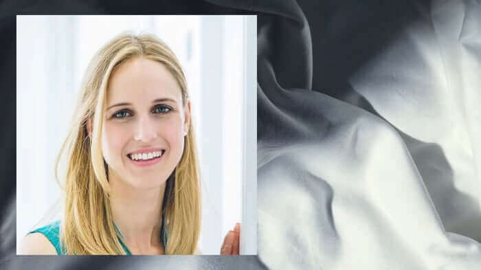 Smiling blonde woman with clear, healthy skin showcasing the benefits of proper sleep for skincare