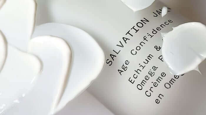 White skincare serum with ectoin ingredient label showing age confidence and skin protection benefits