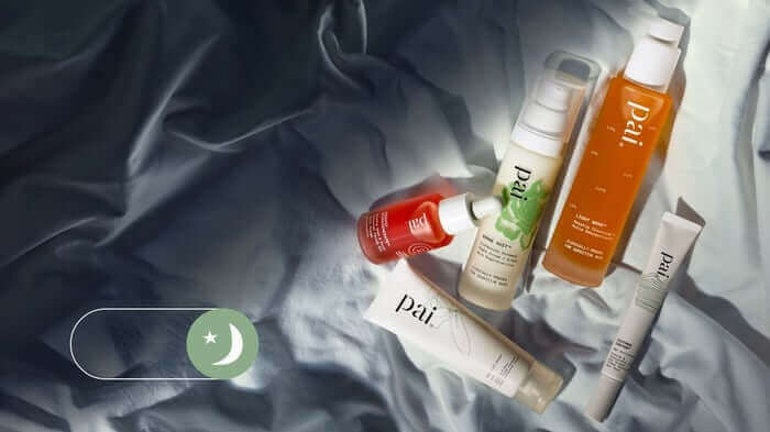 Collection of Pai skincare products arranged on soft grey fabric including cleansers, serums and moisturisers for tired-looking skin