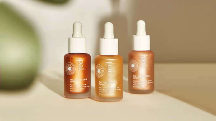Three Pai Skincare glow drops bottles in amber glass with white droppers, featuring different formulations for sensitive skin in warm natural lighting