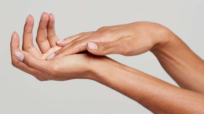 Cupped hands showing smooth, moisturised skin against neutral background demonstrating proper hand care routine