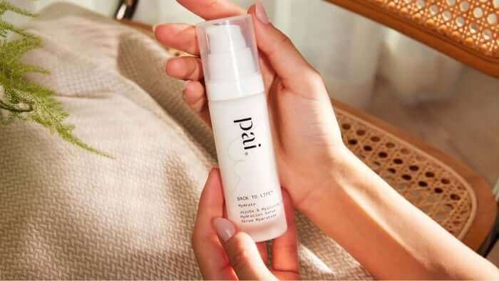 Hands holding Pai Back to Life Hydration Serum in white bottle, gentle skincare for dry skin relief