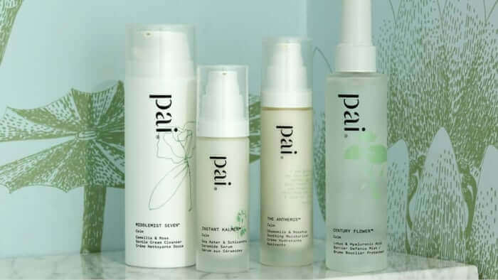 Four Pai Skincare products for sensitive skin lined up on white surface with green botanical leaf illustrations in background