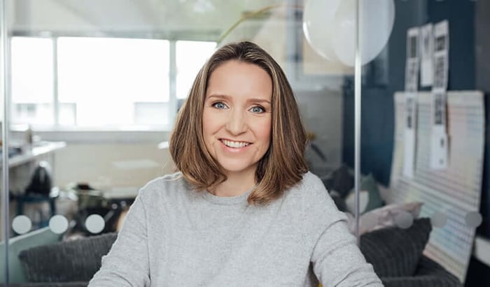 Sarah Brown, Pai Skincare founder, smiling confidently in a bright modern office with natural light