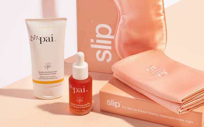 Pai Rosehip BioRegenerate collection displayed with Slip silk pillowcases in warm coral tones for ultimate beauty sleep routine