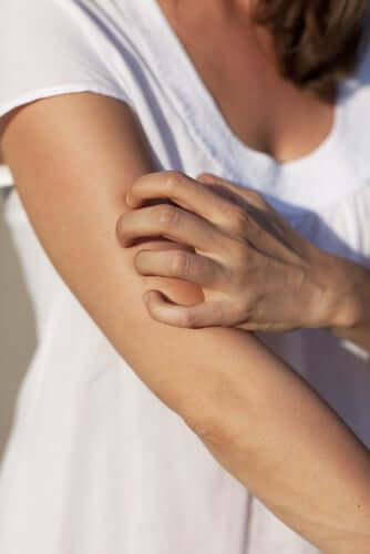 Person scratching eczema on their arm showing irritated sensitive skin