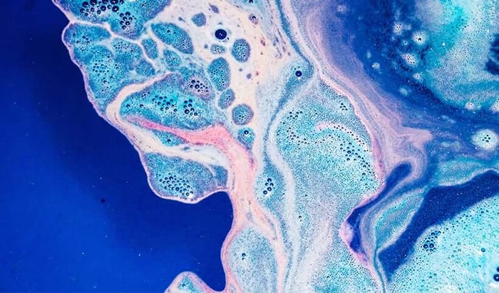 Abstract blue and pink oil-in-water cleansing texture with bubbles and swirling patterns