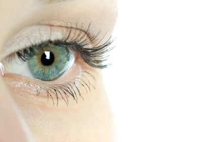 Close-up of a woman's eye with visible milia - small white bumps around the delicate eye area