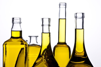 Golden amber plant oils in various glass bottles and flasks arranged together, showcasing natural skincare ingredients