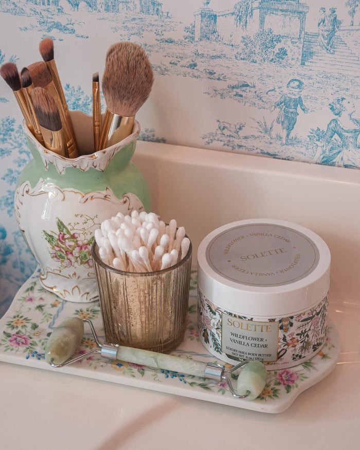 bathroom tray with body butter and various bathroom elements that look styled
