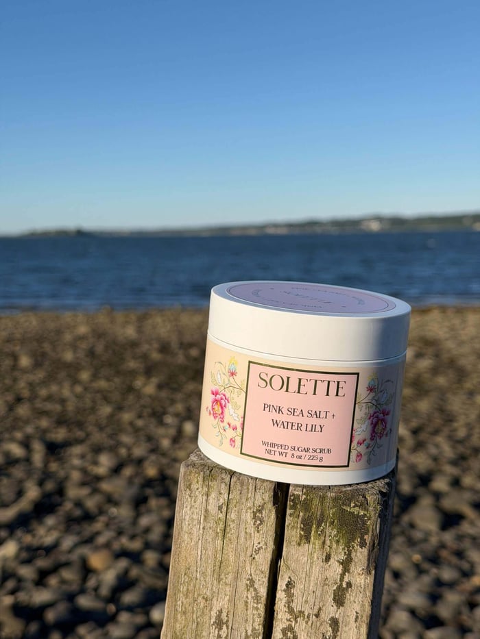 best sensitive skin body care sugar scrub in front of ocean shoreline