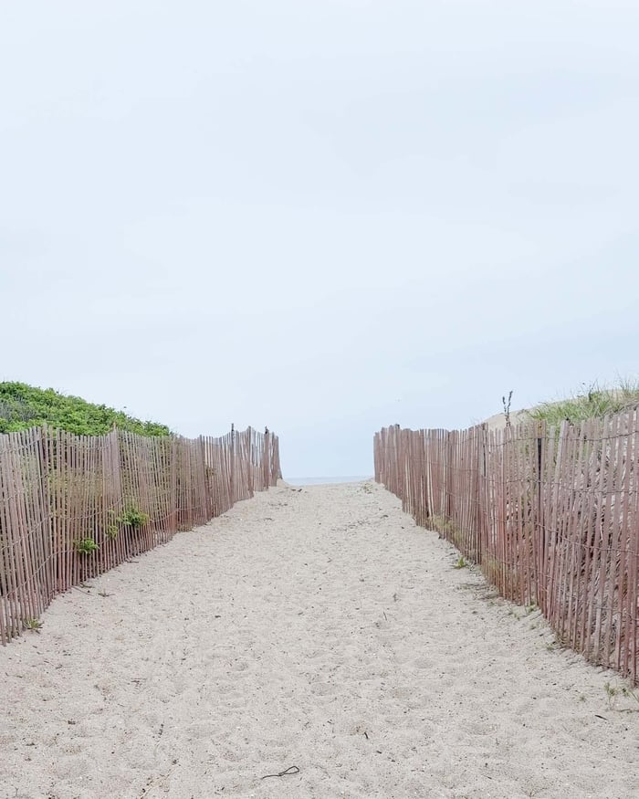 image of a beach with sand and fences to show how beautiful it is without ocean plastic