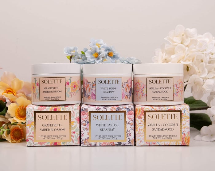 salt scrub vs. sugar scrub collection of stacked jars and boxes of body scrubs and body butters