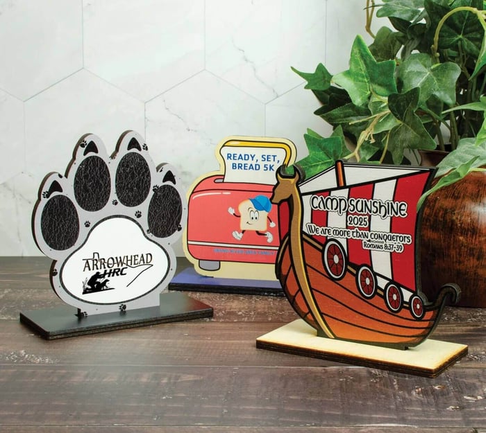 Birchwood awards consisting of two fully custom shape and designed Birchwood trophies and one paw print shape Birchwood trophy with a custom center design.
