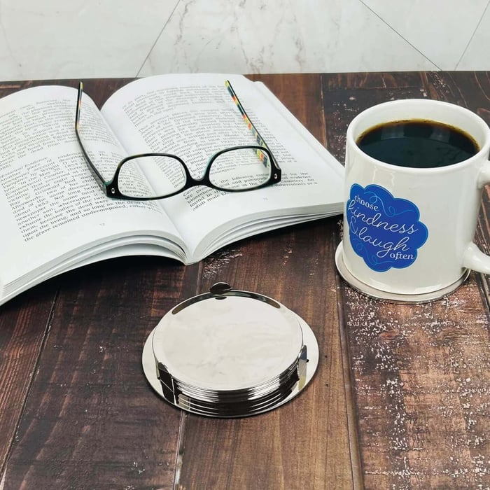 Reading a book with a coffee mug on custom engraved coaster silver awards.