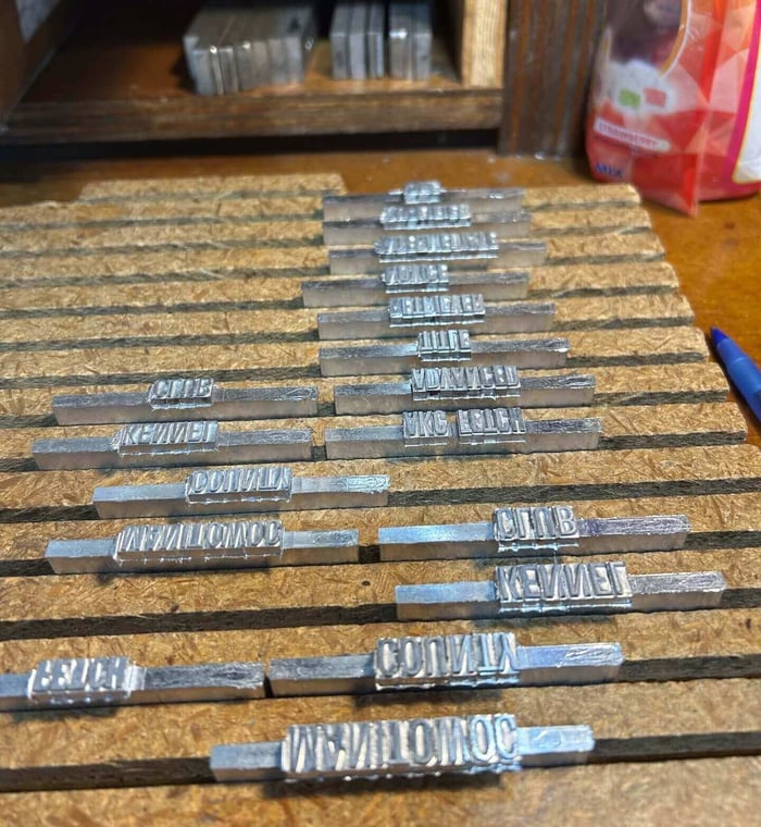 Typesetting with divisions, classes, and titles etched into metal die blocks.