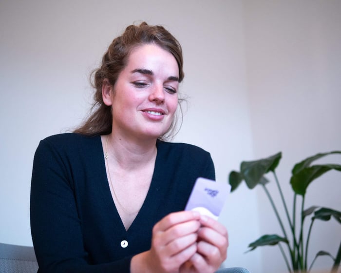 A woman holding Scenario Cards and leaning in to start a deep, meaningful conversation.