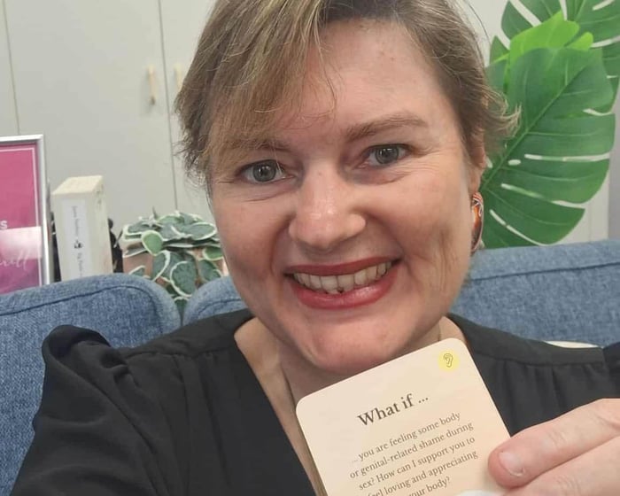 Psychologist Tammy Hatherill holding a card from the Scenario Cards Intimacy collection to use with clients.