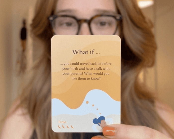 A woman holding up Scenario Cards, demonstrating how 