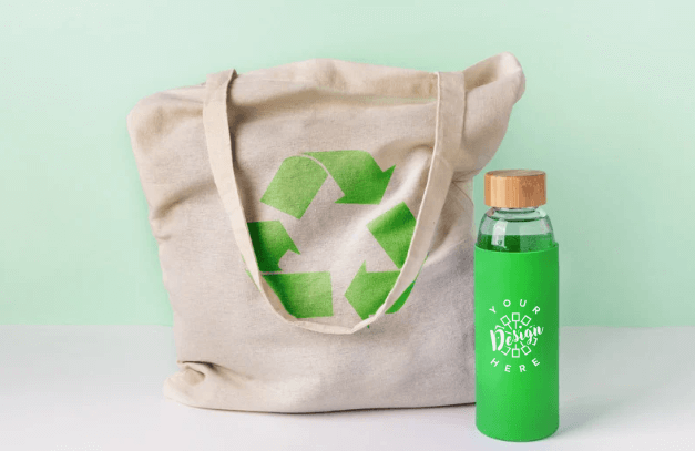 sustainable custom swag including a custom tote bag with a recycling symbol and a custom green water bottle