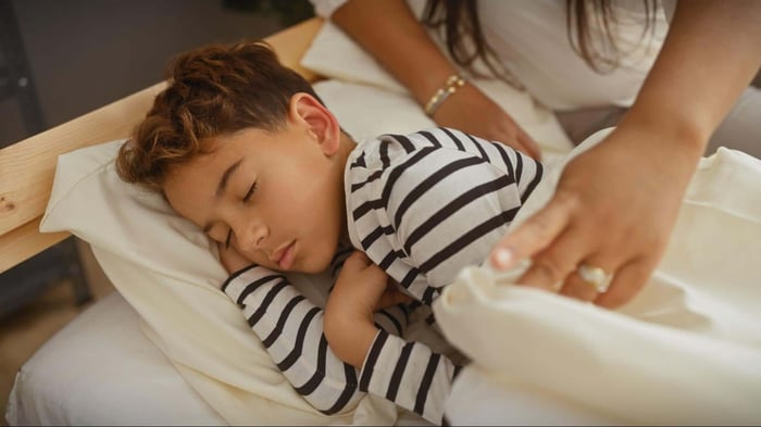 A Kid Sleeping Comfortably in a SHEEX Covered Bed