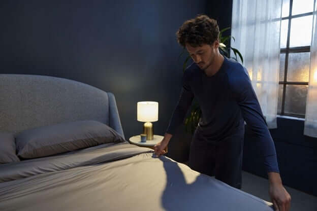 Man Making a Bed With Sheex Cooling Sheets