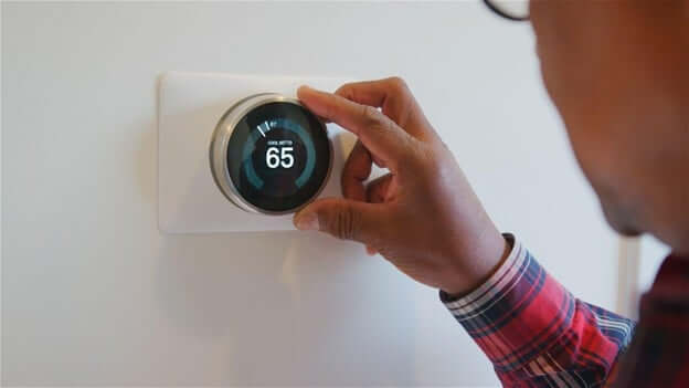 Man Setting His Thermostat