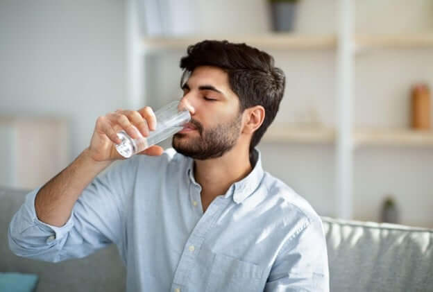 Man Staying Hydrated With Drinking a Glass of Water Trying