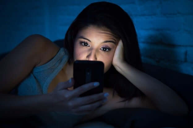 Woman Awake in Bed Scrolling on Her Phone
