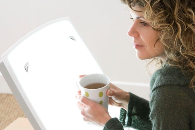 Woman that is Sipping Her Coffee In Front of a Bright Window