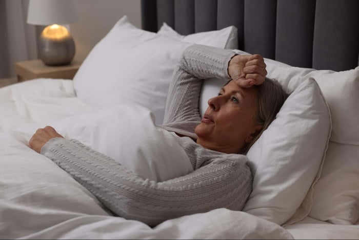 Woman that's stressing in her bed because she is hot and can't fall asleep