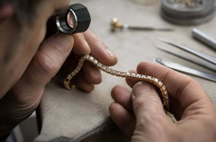Jeweller inspecting the settings of a natural diamond bracelet under magnification