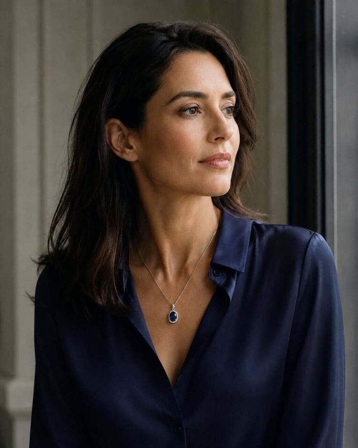 Woman wearing a blue sapphire and natural diamond pendant as part of understated modern styling
