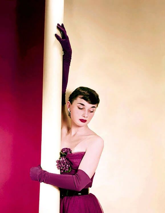 Audrey Hepburn models a rich, purple evening gown for the American Magazine in 1952.