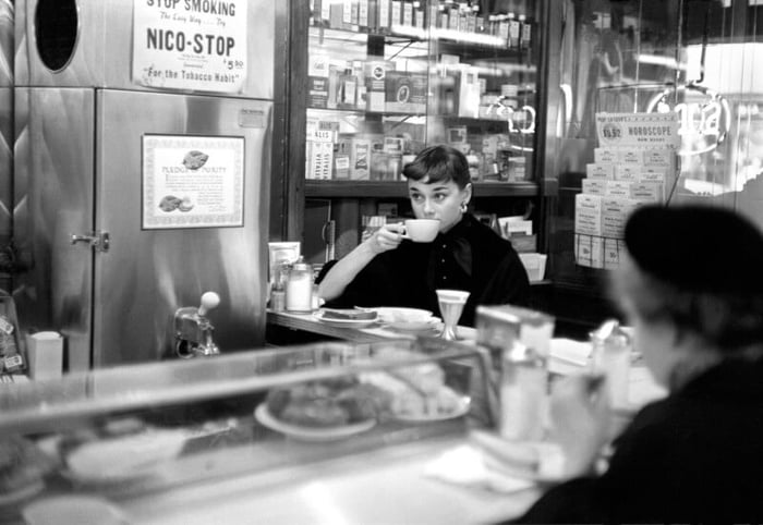 Audrey Hepburn sips on a coffee in a New York café on Broadway in 1951.