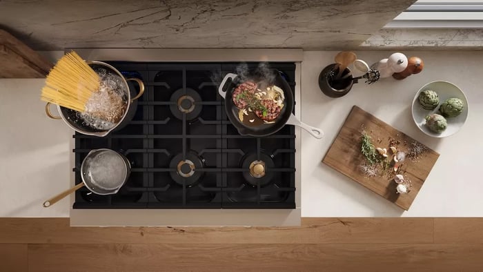 Cooktops vs. Rangetops: Three pots cooking food on gas cooktop from above.