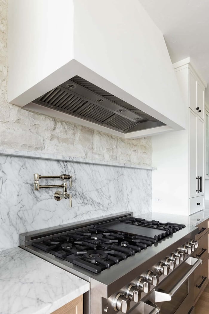 Custom farmhouse-style range hood over a large cooktop