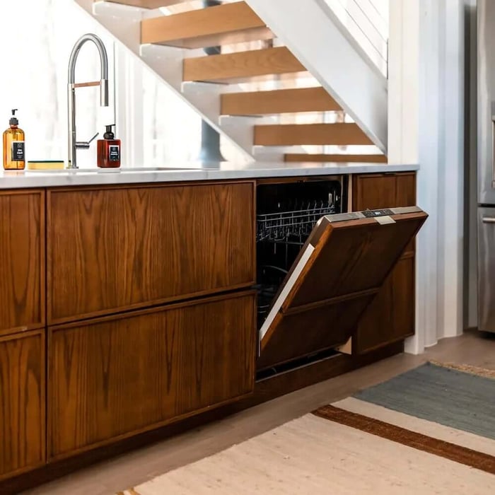 A panel ready dishwasher in a kitchen with red wood details